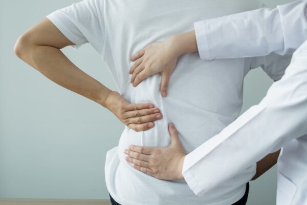 Female physiotherapists provide physical assistance to male patients with back injuries back massages for relaxation and muscle recovery in the rehabilitation center.